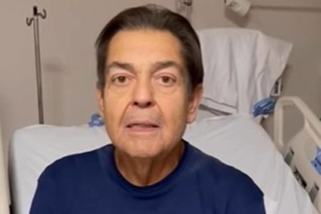 Foto colorida de Fausto Silva, o Faustão, no hospital. Ele é um homem branco de cabelos pretos, veste uma camiseta azul e está com a boca levemente aberta - pós-transplante - Metrópoles