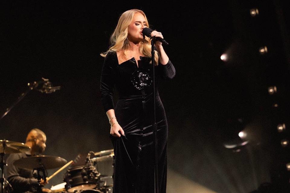 Foto colorida da cantora Adele performando em cima do palco - Metrópoles