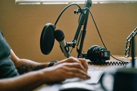 mãos de homem gravando podcast - metrópoles