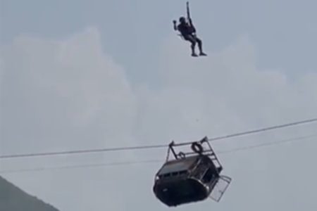 Imagem colorida de equipe resgatando pessoas presas em um teleférico no Paquistão - Metrópoles