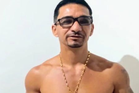 Foto colorida mostra Sergio Luís Pereira, homem branco sem camisa com cordão de ouro e óculos. Ele tem cabelo preto e olha para a câmera - Metrópoles