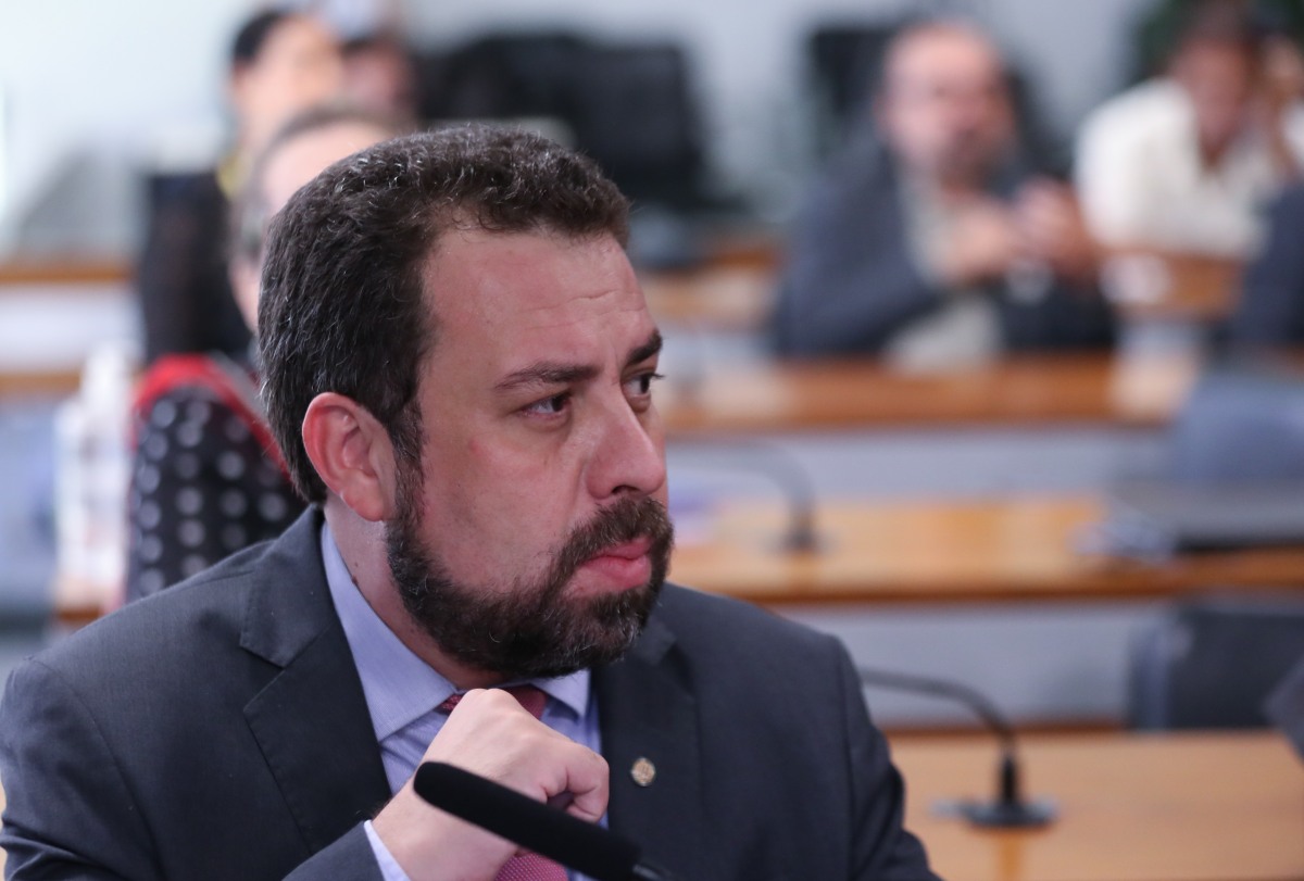 Boulos Imagem colorida mostra o deputado Guilherme Boulos em um dos auditórios da Câmara. Homem branco, de cabelo e barba castanhos, ele veste terno cinza - Metrópoles