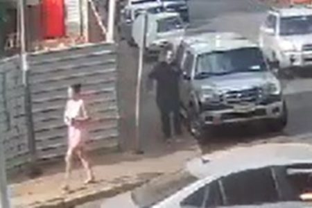 Imagem colorida mostra mulher atravessando rua