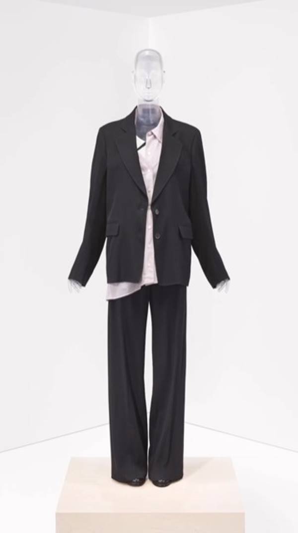 Look de exposição sobre estilistas mulheres Manequim veste blazer e calça escuros - Metrópoles