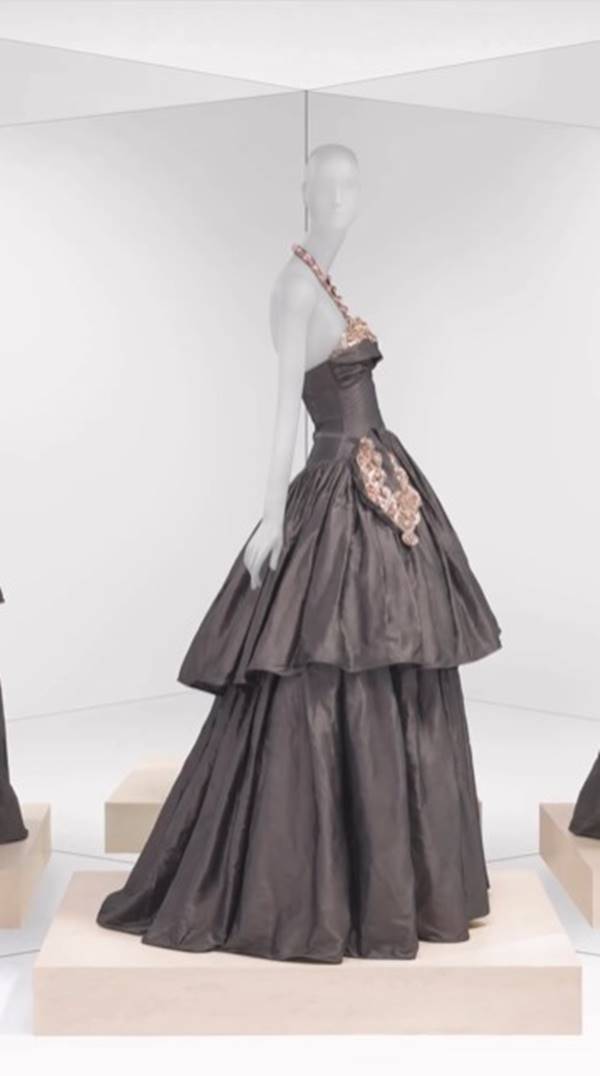 Look de exposição sobre estilistas mulheres Manequim veste vestido cinza com volume - Metrópoles