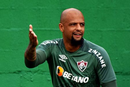 Imagem colorida de Felipe Melo em frente a muro verde - Metrópoles