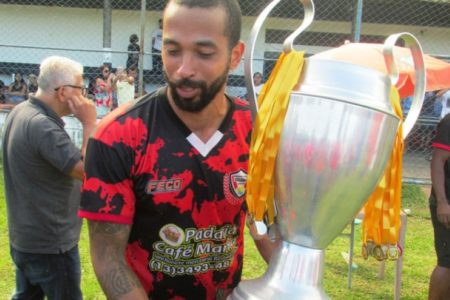 foto em pb de jogador da várzea com a taça na mão - Metropoles