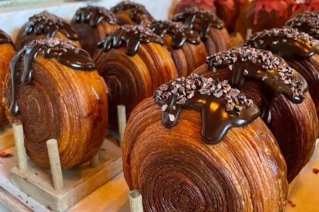 Foto colorida de um croissant redondo com cobertura - Metrópoles