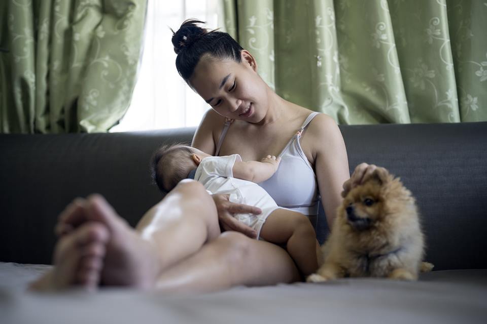 Mãe amamentando seu bebê na sala de estar - Metrópoles