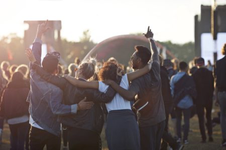 Foto com quatro pessoas abraçadas em festival de música - Metrópoles