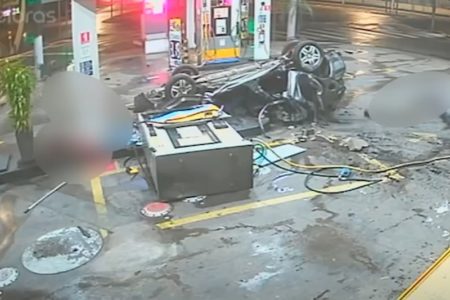 foto colorida mostra carro de ponta cabeça após derrubar bomba de gasolina em posto de combustível - Metrópoles