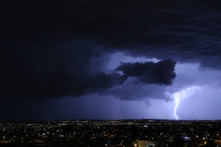 Imagem colorida de céu nublado, com raio atingindo a cidade de Curitiba - Metrópoles