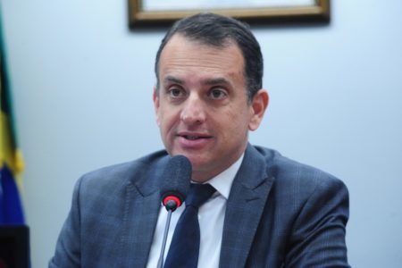 Fotografia colorida de Marco Bertaiolli, homem branco falando ao microfone - Metrópoles