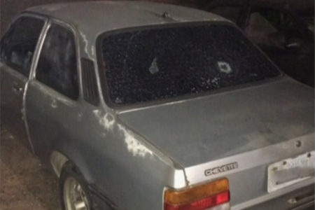 Imagem colorida de carro cinza com vidro traseiro baleado - Metrópoles