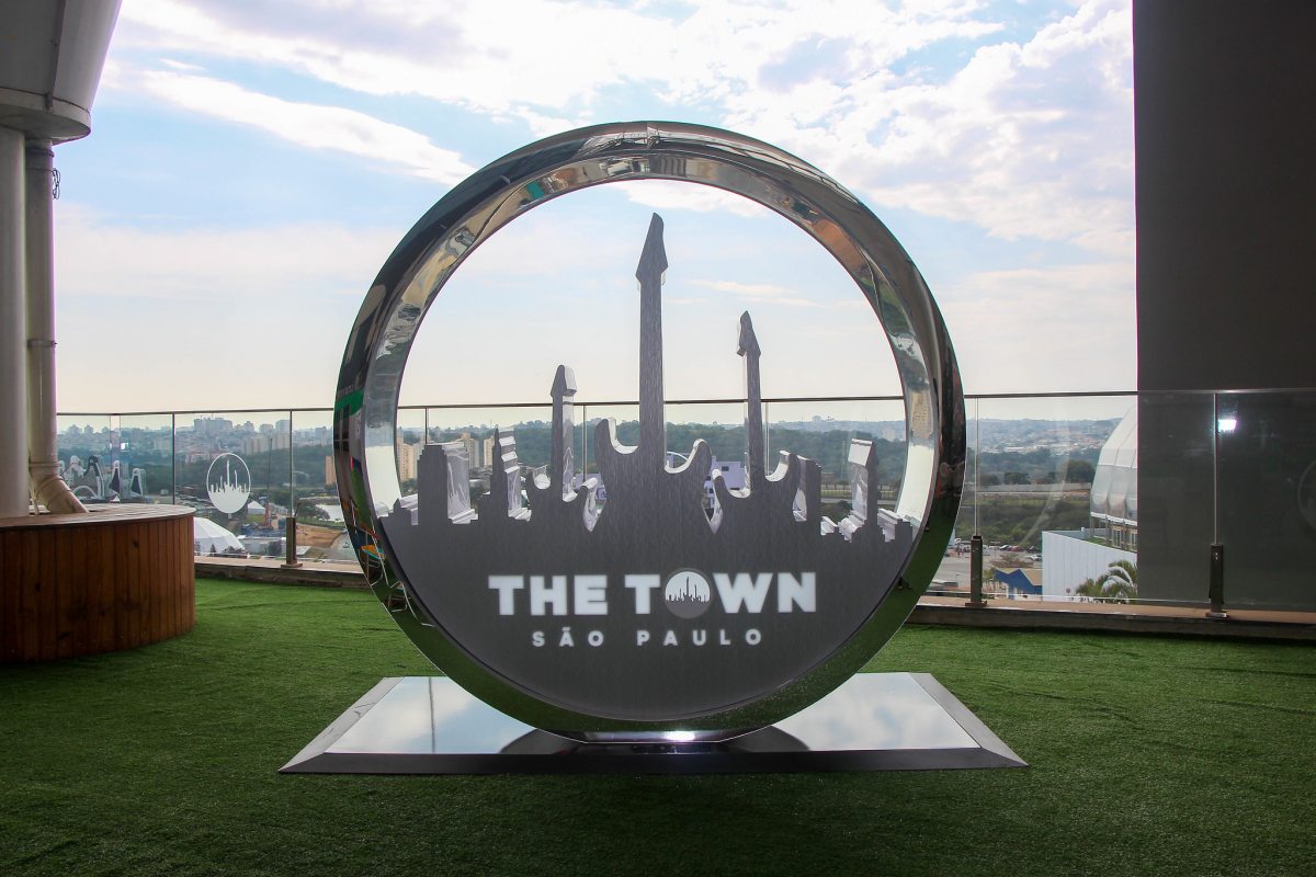Imagem colorida mostra escultura redonda com logotipo do festival The Town em um piso que imita grama - Metrópoles