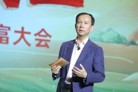 De terno azul e camisa branca, Daniel Zhang, ex-CEO do Alibaba, faz palestra. Ele tem um microfone de lapela - Metrópoles