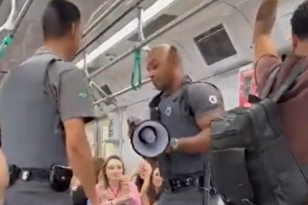 foto colorida mostra dois agentes de segurança da ViaMobilidade dentro de um trem da Linha 9 dançando; um deles segura um megafone - Metropoles