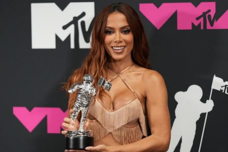 Foto colorida de Anitta segurando o prêmio do VMA - Metrópoles