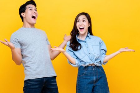 casal sorrindo de blusa clara com as mãos pra cima - Metrópoles