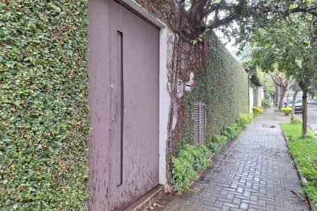 foto colorida de fachada de casa com portão escuro e muro alto em SP - Metrópoles