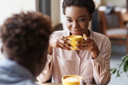 Foto colorida de mulher tomando café no primeiro encontro - Metrópoles