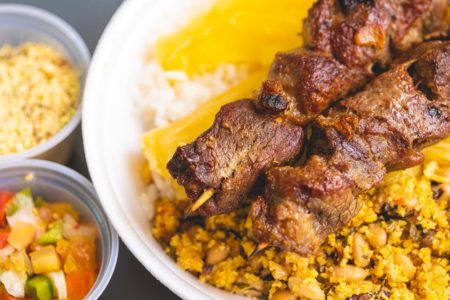 Foto de um prato de comida com arroz, mandioca e carne - Metrópoles