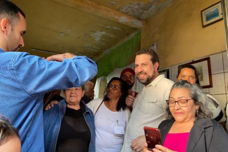 Imagem colorida mostra Guilherme Boulos tirando foto com apoiadores - Metrópoles