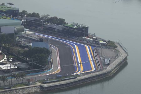 Imagem colorida de pista de corrida da Formula 1 do GP de Singapura vista de cima, tempo nublado, lado direito há um lago - Metrópoles