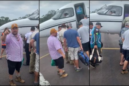 Imagem colorida mostra grupo de pescadores embarcando em avião