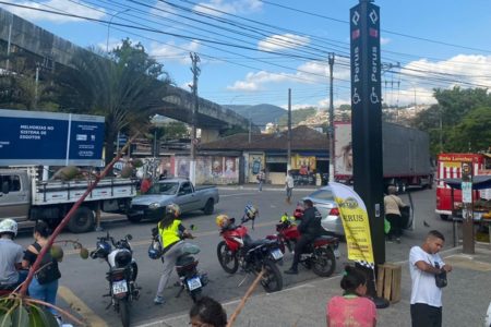 Imagem colorida mostra calçada na frente da estação Perus da rede de trens, com mototáxis estacionados na frente