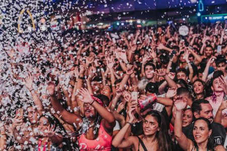 Imagem festa com confetis e aglomeração de pessoas