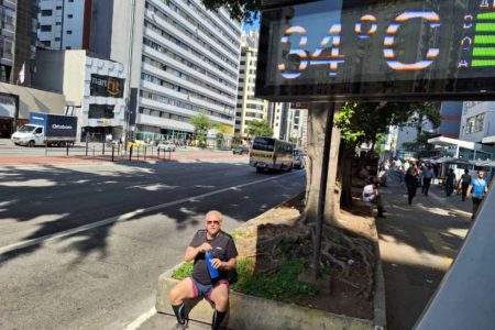 foto colorida de homem com garrafa de água na Avenida Paulista, perto de termômetro que marca 34 graus - Metrópoles