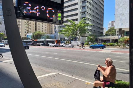 foto colorida de homem sentindo calor sem camisa na Avenida Paulista, perto de termômetro que marca 34 graus - Metrópoles