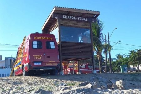 Imagem colorida mostra uma viatura do Corpo de Bombeiros ao lado de um posto de observação dos salva-vidas em uma praia no Guarujá, litoral de São Paulo - Metrópoles