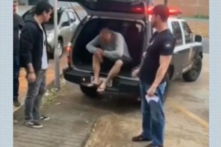 Imagem colorida de homem saindo da viatura da Polícia Civil - Metrópoles