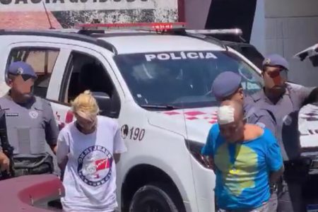 Em foto colorida casal é escoltado por policias militares - Metrópoles