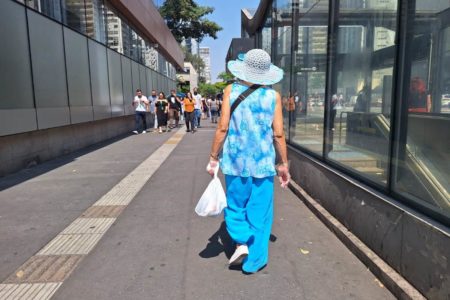 foto colorida mostra mulher caminhando de chapéu sob sol em trecho da Avenida Paulista; SP vive onda de calor atípico - Metrópoles