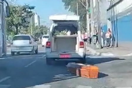 Foto colorida de caixão caído no meio da rua - Metrópoles