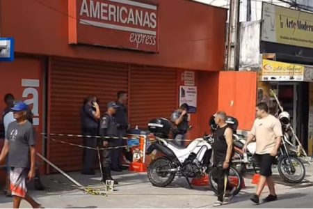 Imagem colorida da fachada da Lojas Americanas. Policiais estão na frente da porta isolando o local - Metrópoles