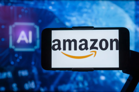 Celular da Amazon, com o logotipo da empresa na tela. Um fundo azul as letras "AI", de "inteligência artificial" - Metrópoles