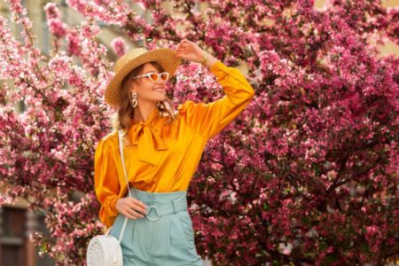 Mulher de chapéu na primavera estação cheio de flores rosas