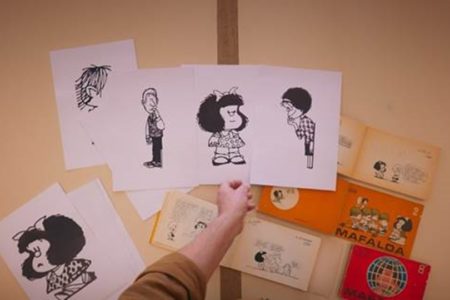 Foto colorida de uma mesa com vários desenhos da Mafalda - Metrópoles