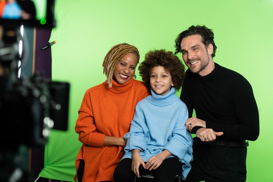 Aline Wirley com blusa laranja, com menino de blusa azul e Igor Rickli com blusa preta com fundo verde - Metrópoles