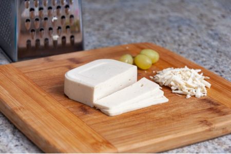 Queijo vegano picado e ralado em cima de uma tabua