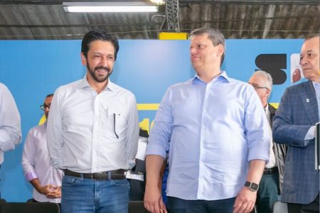 Nunes, em pé e olhando para o horizonte, ao lado de Tarcísio, que tem o rosto virado para a direita - Metrópoles
