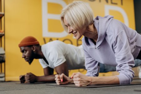 Homem e mulher fazendo exercício de prancha no chão - Metrópoles