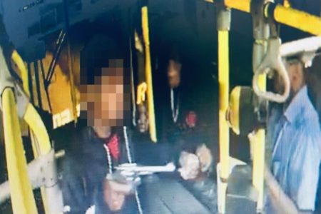 Imagem colorida mostra homem armado na catraca de ônibus