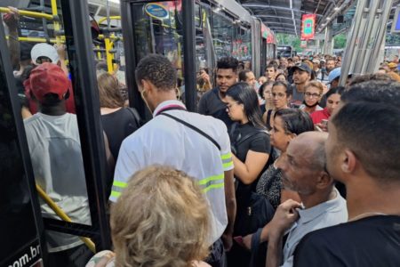 Imagem colorida mostra muitas pessoas tentando entrar em ônibus na frente da estação Pinheiros - Metrópoles