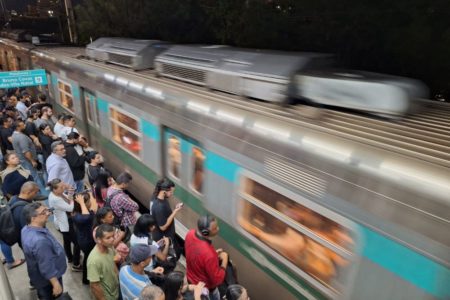 Imagem colorida mostra trem passando na linha 9 da CPTM, administrada pela ViaMobilidade, em São Paulo, enquanto pessoas esperam pelo lado de fora - Metrópoles