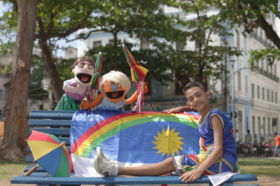 Foto colorida de um menino com fantoche - Metrópoles